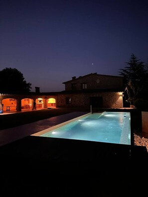 Una piscina con un edificio de piedra al fondo.