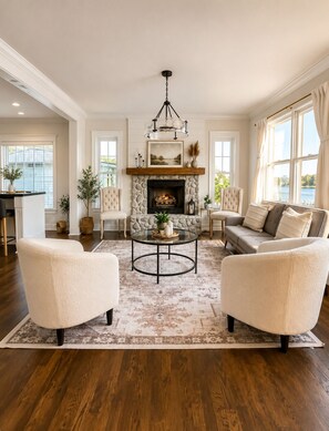 A living room with a fireplace, two armchairs, a sofa, and a coffee table.