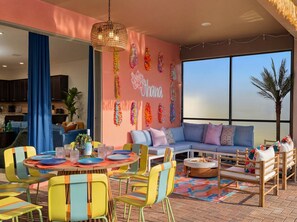 Ein modernes Wohnzimmer mit einer Couch, bunten Stühlen, einem Esstisch und einem Kamin.