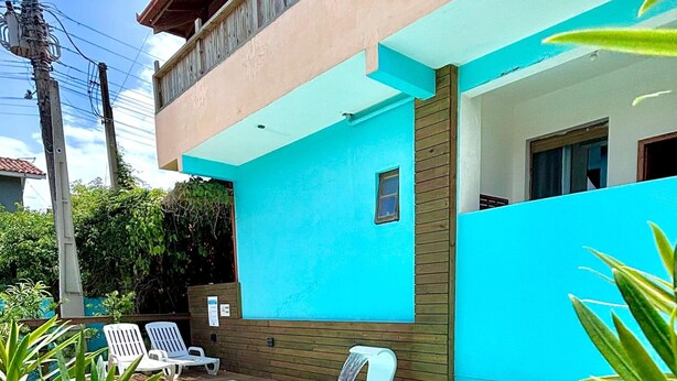 A two-story house with a swimming pool, wooden deck, and a small garden area. - Pousada Astral (Imbituba)