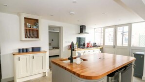 A modern kitchen with a central island, white cabinetry, and a view of the outside.
