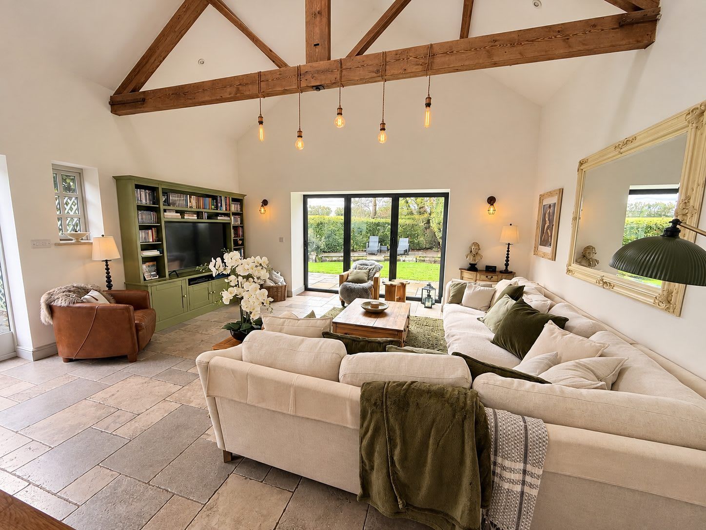 A living room with a sofa set, a television, and a bookshelf.