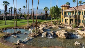 Ein Resort mit Pool, Palmen und Golfplatz.