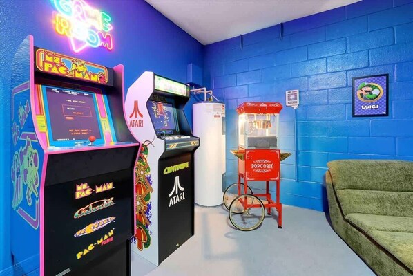 Una stanza con giochi arcade, una macchina distributrice e un carrello accessibile per sedia a rotelle.
