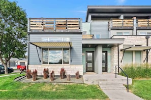 A modern two-story building with a flat roof, large windows, and a covered front porch. - Rocky Retreat Near Old Town | Hot Tub | Fireplace (Fort Collins)