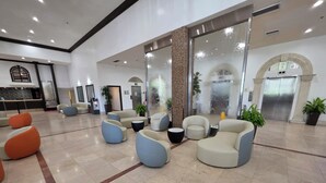 A spacious lobby with modern seating, a reception desk, and an elevator. - Beautiful Oceanfront Studio in Marco Polo Sunny Isles Beach (Sunny Isles Beach)