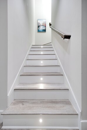 Eine Treppe mit weißen Wänden und einem Gemälde an der Wand.