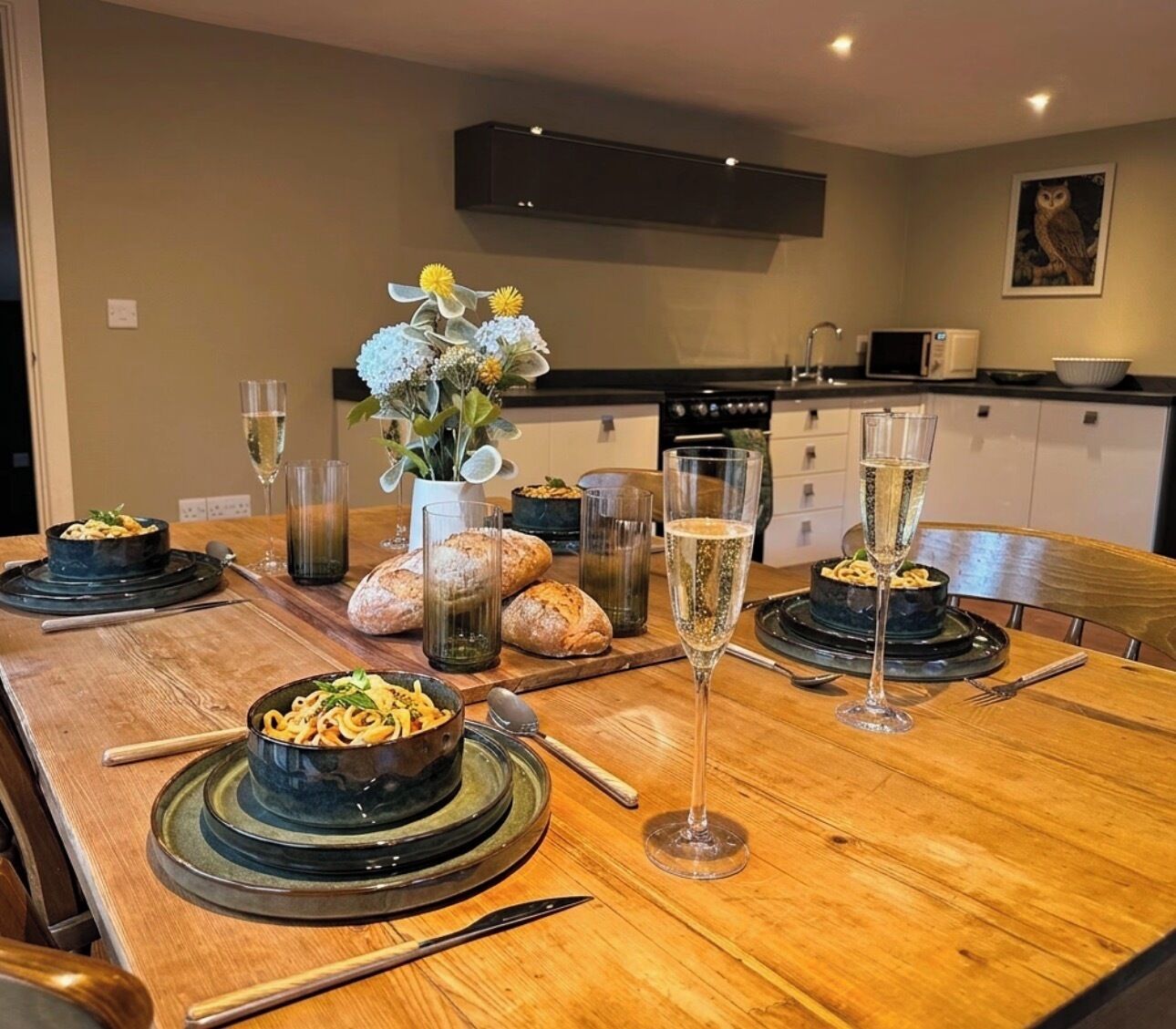 A dining table set with dishes, glasses, and bread.