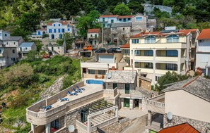 Ein mehrstöckiges Gebäude mit Pool, Steinfassade und Balkonen.