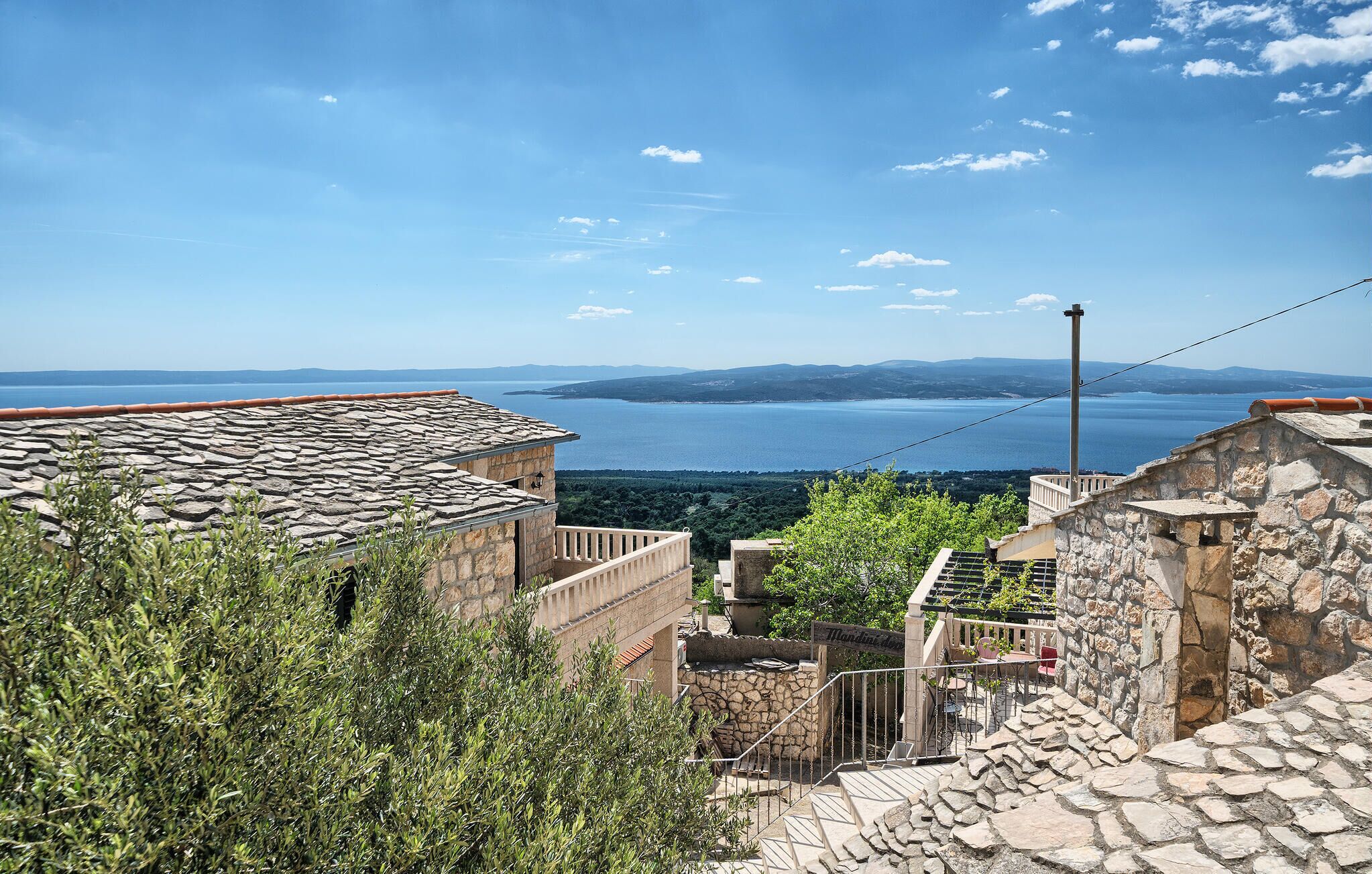 Un edificio de piedra con vistas a un lago y montañas distantes.