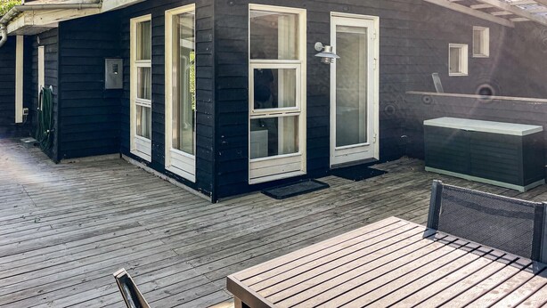 A wooden deck with a bench and a grill area. - Lovely home in Gistrup with WiFi (Gistrup)
