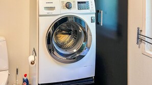 A Samsung digital washing machine in a room with a black floor and white walls. - Lovely home in Gistrup with WiFi (Gistrup)