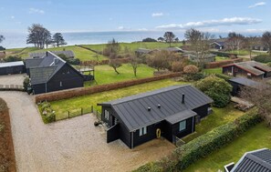 Ein Wohngebiet mit Häusern, einer grünen Wiese und Blick aufs Meer.