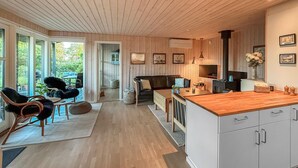 Moderni keittiö, jossa on puinen katto, valkoiset kaapit ja puinen työtaso.