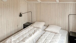 Une chambre à coucher avec un lit, une table de chevet, une lampe et une armoire.