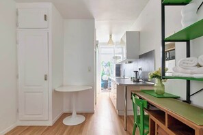 Une cuisine compacte avec un coin repas, une porte blanche et une vue sur une salle à manger.