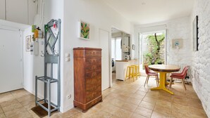 Una cocina con un armario de madera, un taburete metálico y una mesa de comedor con sillas.
