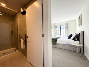 Ein modernes Badezimmer mit einer Duschkabine aus Glas und einer separaten Toilette.