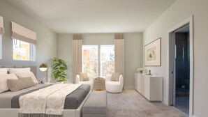 Un dormitorio con una cama, dos sillas, una mesita y una puerta que da al baño.