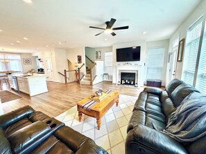 A spacious living room with a fireplace, a dining area, and a kitchen in the background. - Spectacular 4 bed/3.5 Bath Chantilly/Northern Virginia Townhouse (Chantilly)