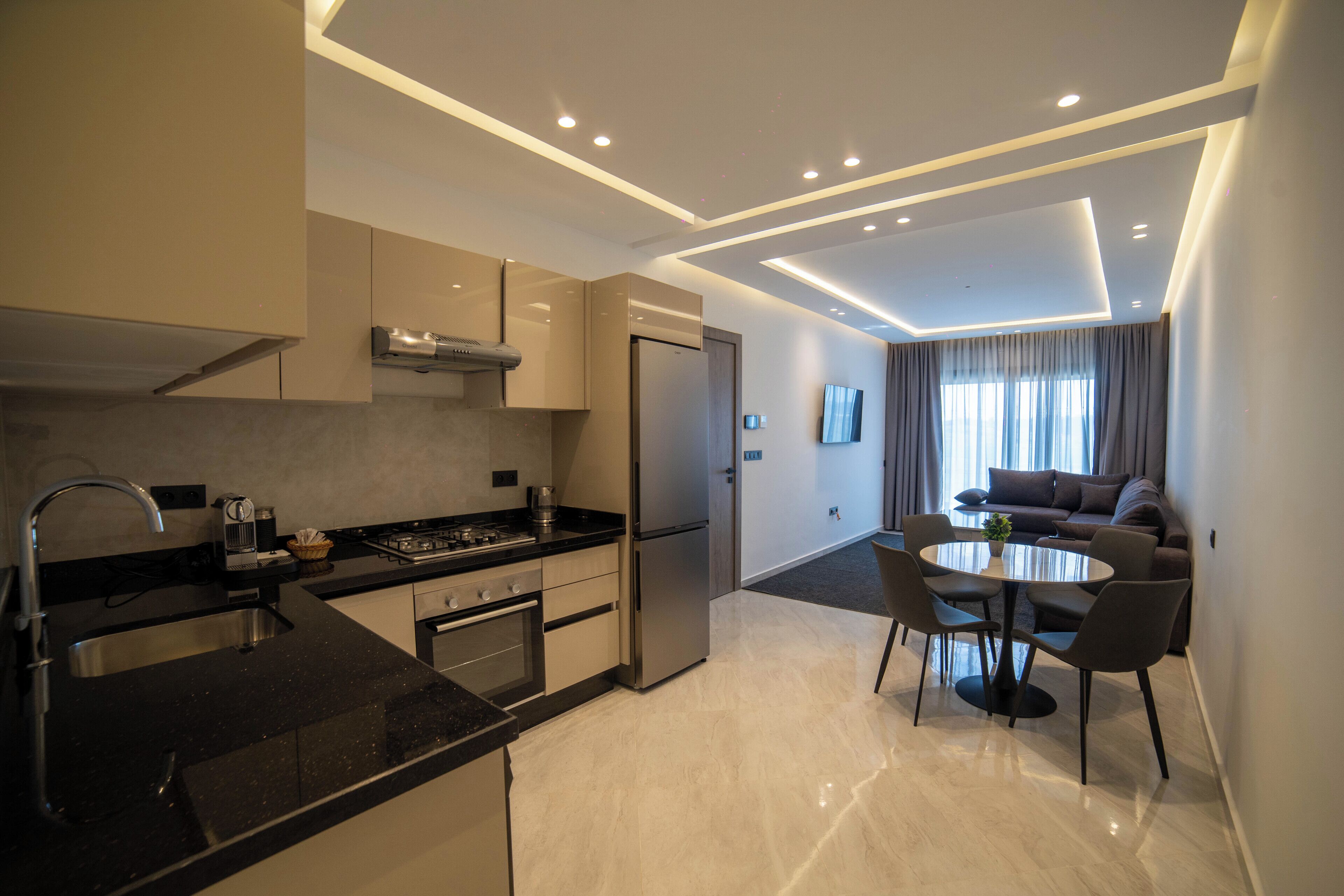 Una cocina moderna con comedor, horno empotrado y refrigerador.