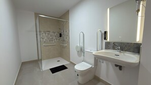 Un baño moderno con cabina de ducha, inodoro y lavamanos.