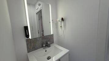 Comfort eenpersoonskamer, gemeenschappelijke badkamer | Badkamer | Een haardroger, handdoeken, zeep, shampoo