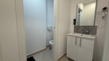 Comfort tweepersoonskamer | Badkamer | Een haardroger, handdoeken, zeep, shampoo