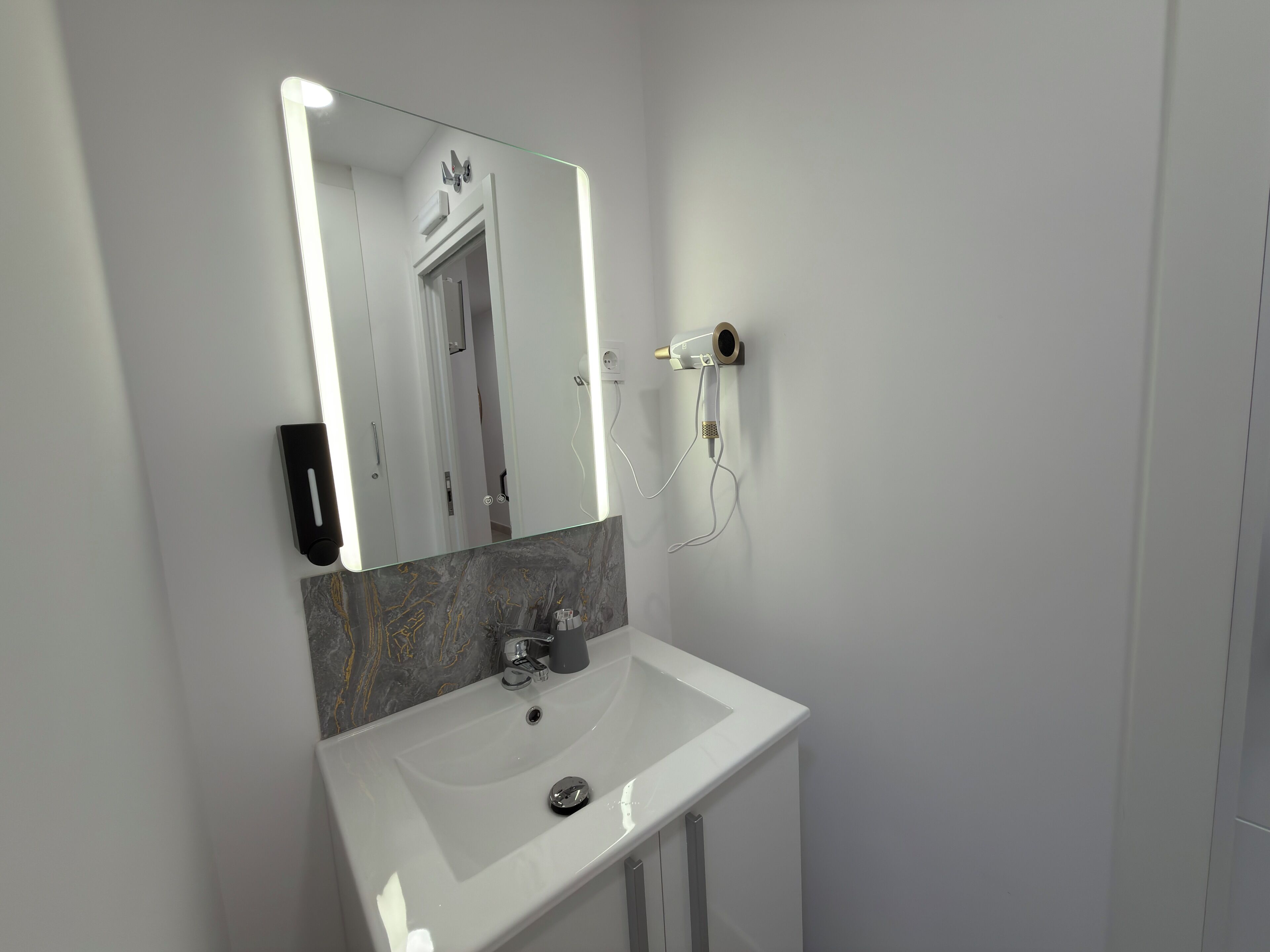 Comfort tweepersoonskamer | Badkamer | Een haardroger, handdoeken, zeep, shampoo