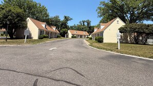 A street leading to a row of guest rooms with a sign indicating room numbers 150-130. - Princess Anne Hotel, SureStay Collection by Best Western (Williamsburg)