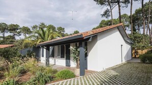 Ein modernes Haus mit weißer Fassade, einem Ziegeldach und einer überdachten Veranda.