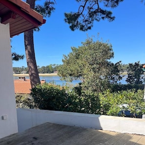 Ein Balkon mit Blick auf einen See und umliegende Bäume.
