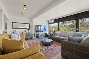 A modern living room with a sofa, a coffee table, and a television.