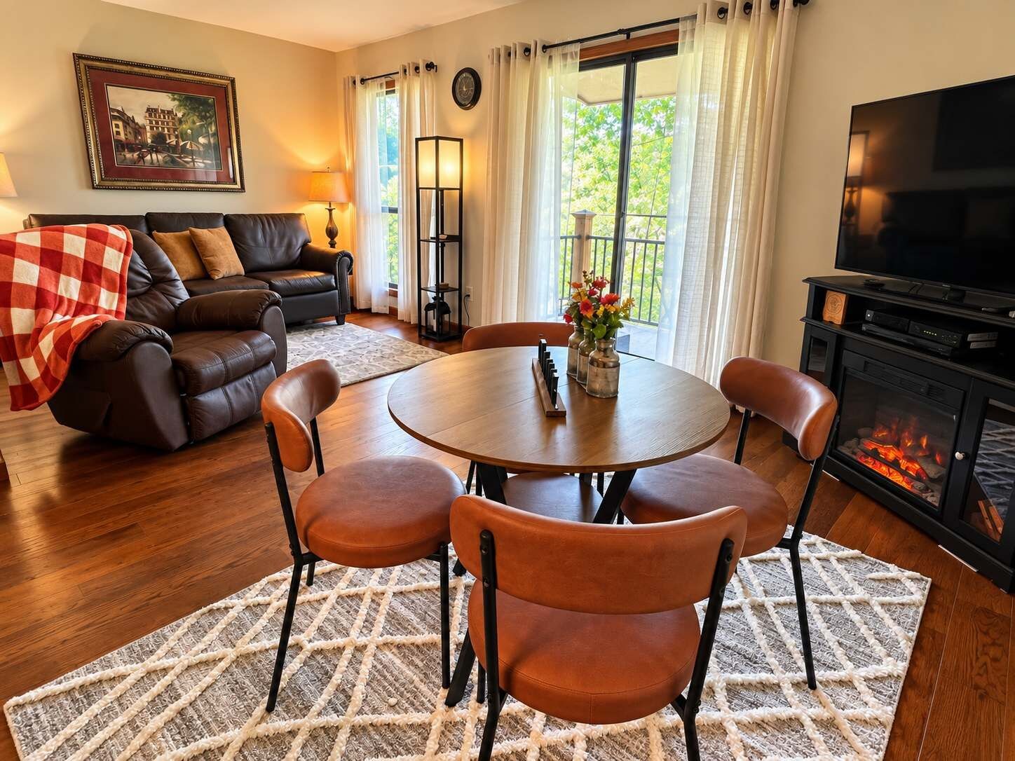 Una sala de estar acogedora con chimenea, una mesa de comedor con sillas, un sofá y una televisión.