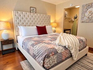 A bedroom with a tufted headboard, a floral quilt, and a white throw blanket. - Fairway Heights-Pointe Royale Golf Resort-Pools (Branson)