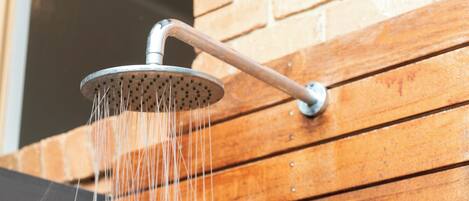 A showerhead with water flowing from it, mounted on a wooden surface.