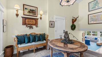 A cozy living room with a wooden sofa, a round coffee table, and a decorative deer head.