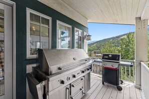 A covered outdoor area with a stainless steel grill and a barbecue, overlooking a mountainous landscape. - LUXE 6BR Vail Retreat | Hot Tub | 8 Min to Slopes (Vail)