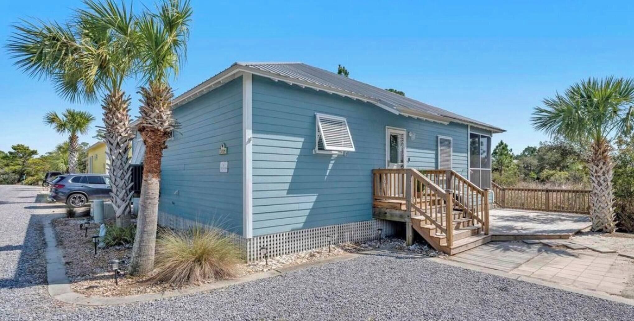Een gelijkvloers huis met een houten terras en een overdekte veranda.