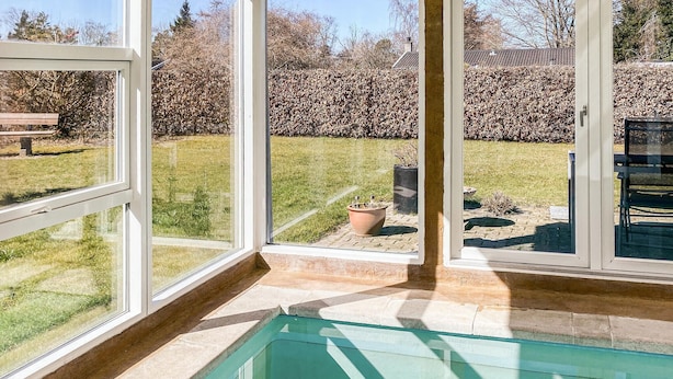 Una piscina con vista aperta sul giardino circostante e una panchina sullo sfondo.