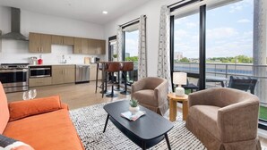Um apartamento moderno com cozinha, sala de jantar e varanda com vista.
