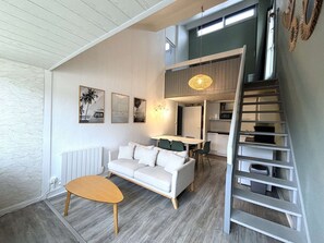 Ein modernes Interieur mit einer Essnische im Loft-Stil, einer Treppe und einer Couch.
