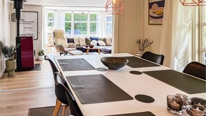A modern dining area with a long table, black placemats, and a large bowl. - 4 bedroom awesome home in Slagelse (Slagelse)