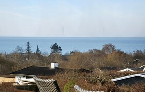 A coastal view with a house, a chair, and a view of the sea. - Lovely home in Slagelse with house sea view (Slagelse)