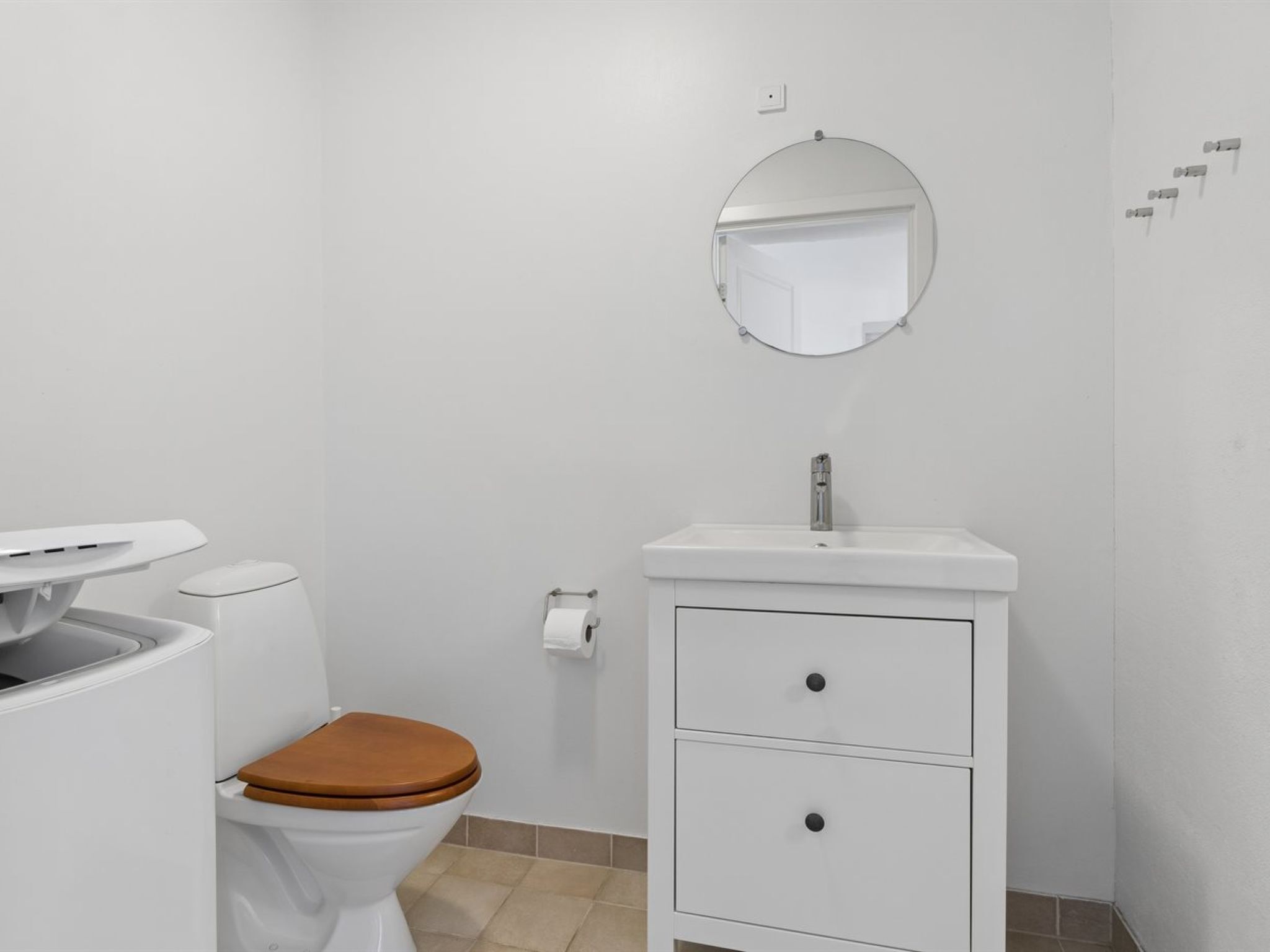 Een badkamer met toilet, wastafel en spiegel.
