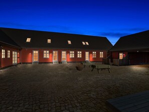 Ein Gebäude mit roter Fassade, zahlreichen Fenstern und einem geneigten Dach.