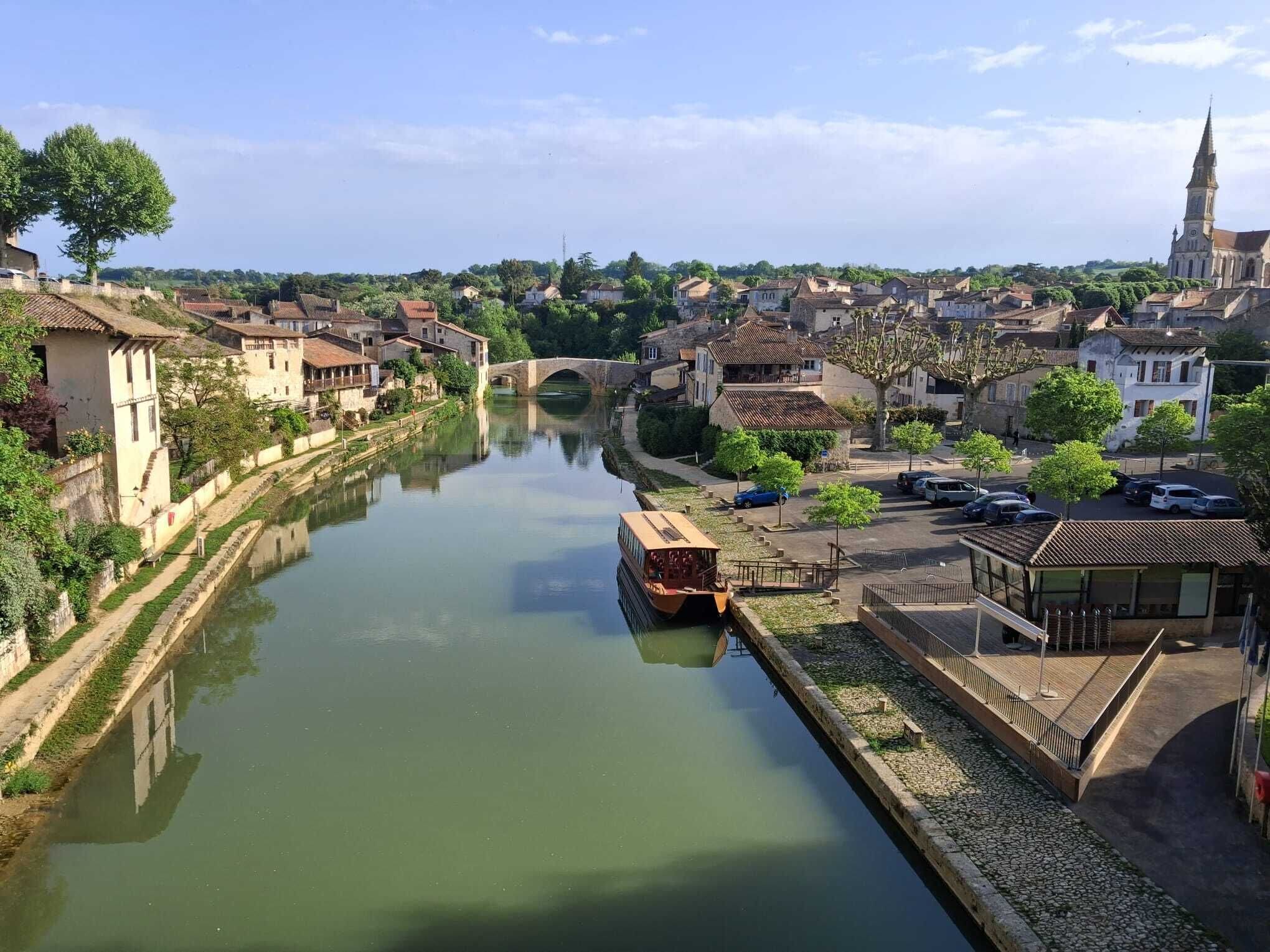 Une rivière avec un pont, des bâtiments et un quai pour bateaux.