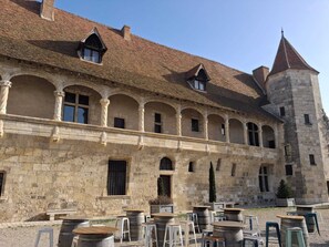 Ein historisches Gebäude mit Innenhof, Steinmauern und einem Turm.