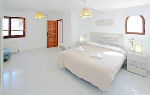 A bedroom with a bed, bedside tables, a bench, a door, and two pendant lights. - Beautiful home in Calpe (Calpe)