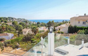 Ein Wohngebiet mit Meerblick, einem Schwimmbad und einem Balkon mit Glasgeländer.
